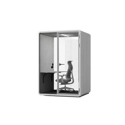 A modern gray acoustic office cubicle with a glass door, interior desk, and chair, shown on a plain white background.