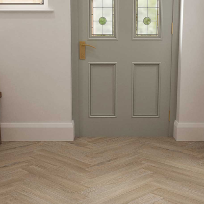 Gray front door with glass panels and a gold handle, featuring a herringbone wood floor.