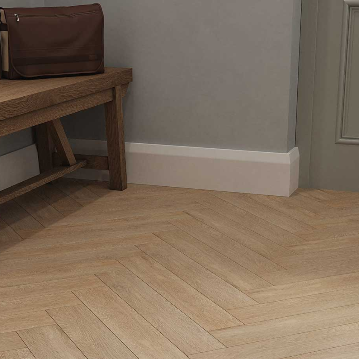 Wooden floor with a herringbone pattern in a room with a wooden bench and a brown bag.